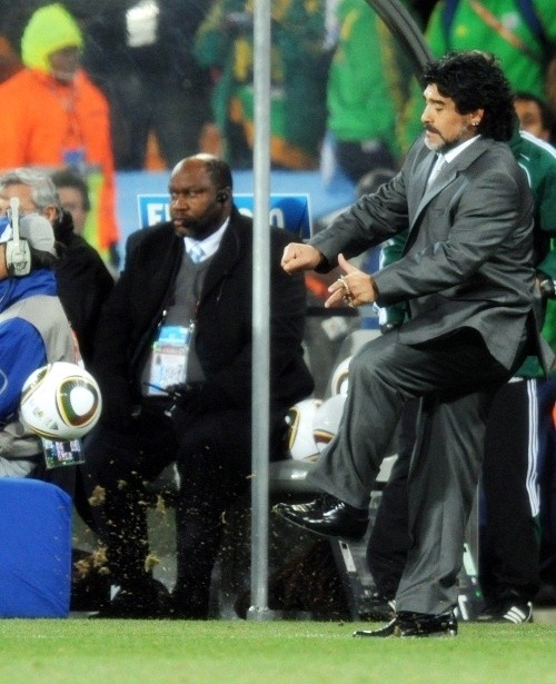 Diego Maradona can't resist a kick from the touchline