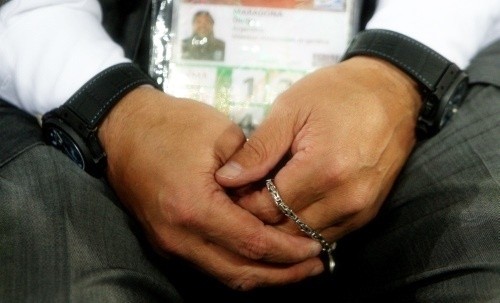 Diego Maradona clutches his rosary beads throughout the match with his left hand