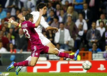 Real Madrid's Kaka shoots past Olympique Lyon's Reveillere during their Champions League soccer match at Real Madrid's Santiago Bernabeu stadium
