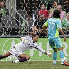 Seattle Sounders forward Freddy Montero scores a goal against Chelsea's goal keeper Henrique Hilario during the first half of their friendly soccer match in Seattle