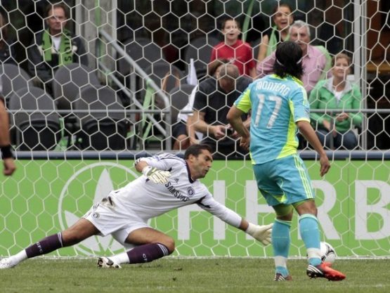 Seattle Sounders forward Freddy Montero scores a goal against Chelsea's goal keeper Henrique Hilario during the first half of their friendly soccer match in Seattle
