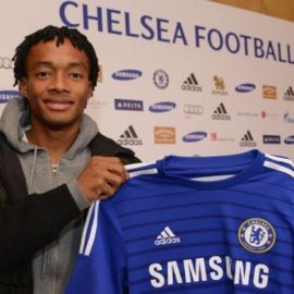 Juan Cuadrado holding a Chelsea shirt after completing his transfer