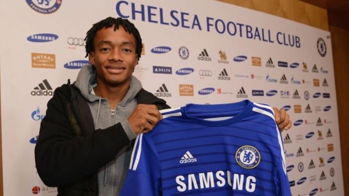 Juan Cuadrado holding a Chelsea shirt after completing his transfer