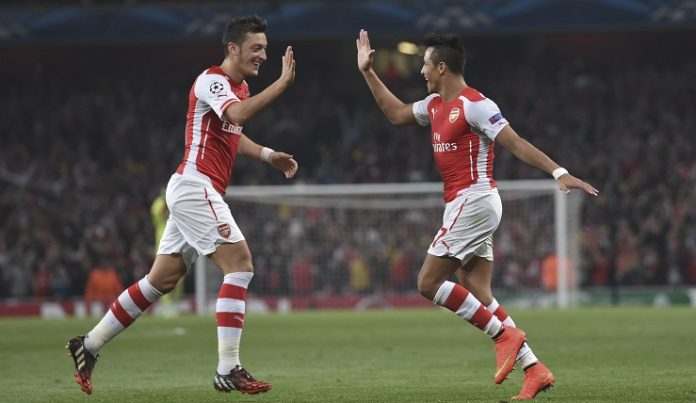 Arsenal's Alexis Sanchez, right, celebrates after scoring against Galatasaray with his teammate Mesut Ozil during the Champions League Group D soccer match between Arsenal and Galatasaray , at the Emirates Stadium in London, on Wednesday, Oct 1, 2014. (AP Photo/ Tim Ireland)